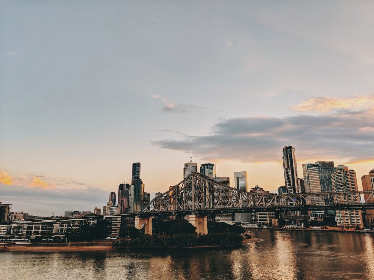 Brisbane's Story Bridge over the Brisbane River at sunset, with the city skyline behind