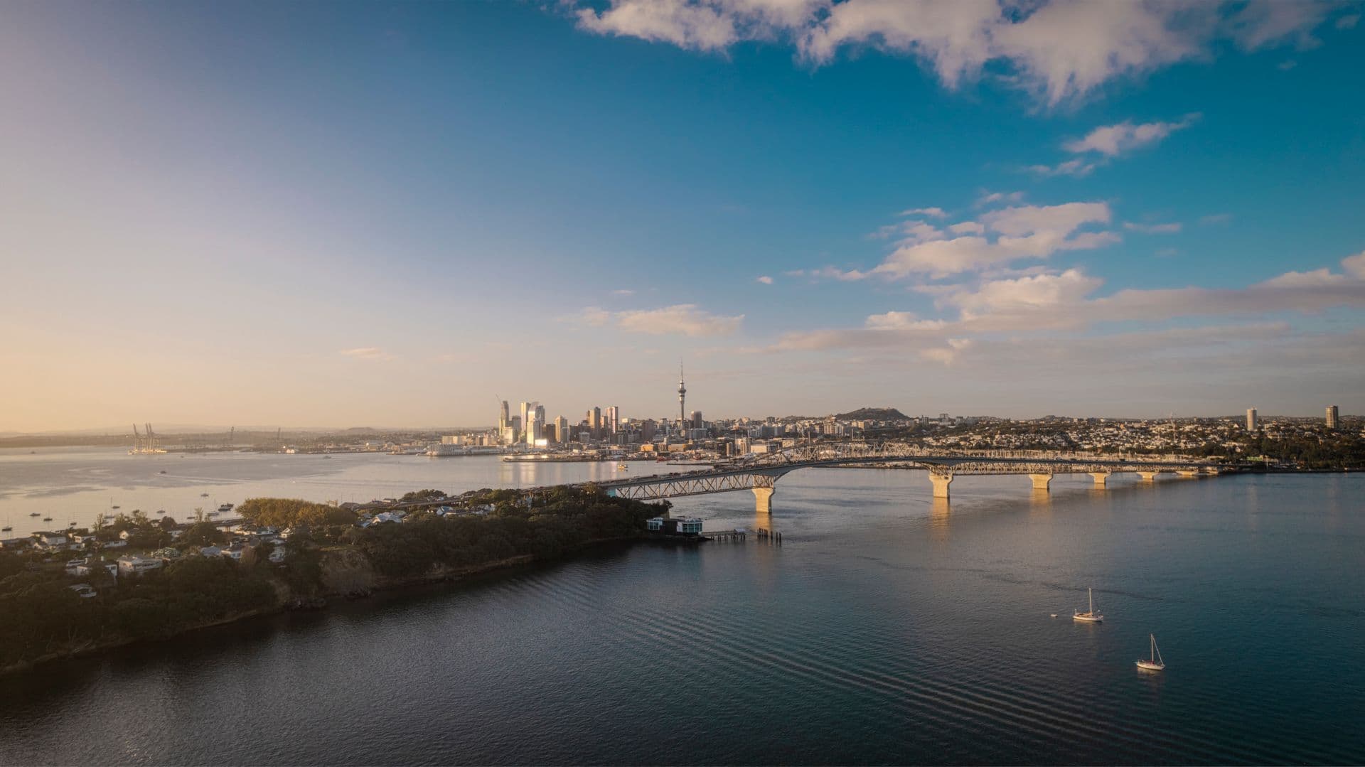 Aerial view of the Auckland Harbour Bridge and city skyline at sunset