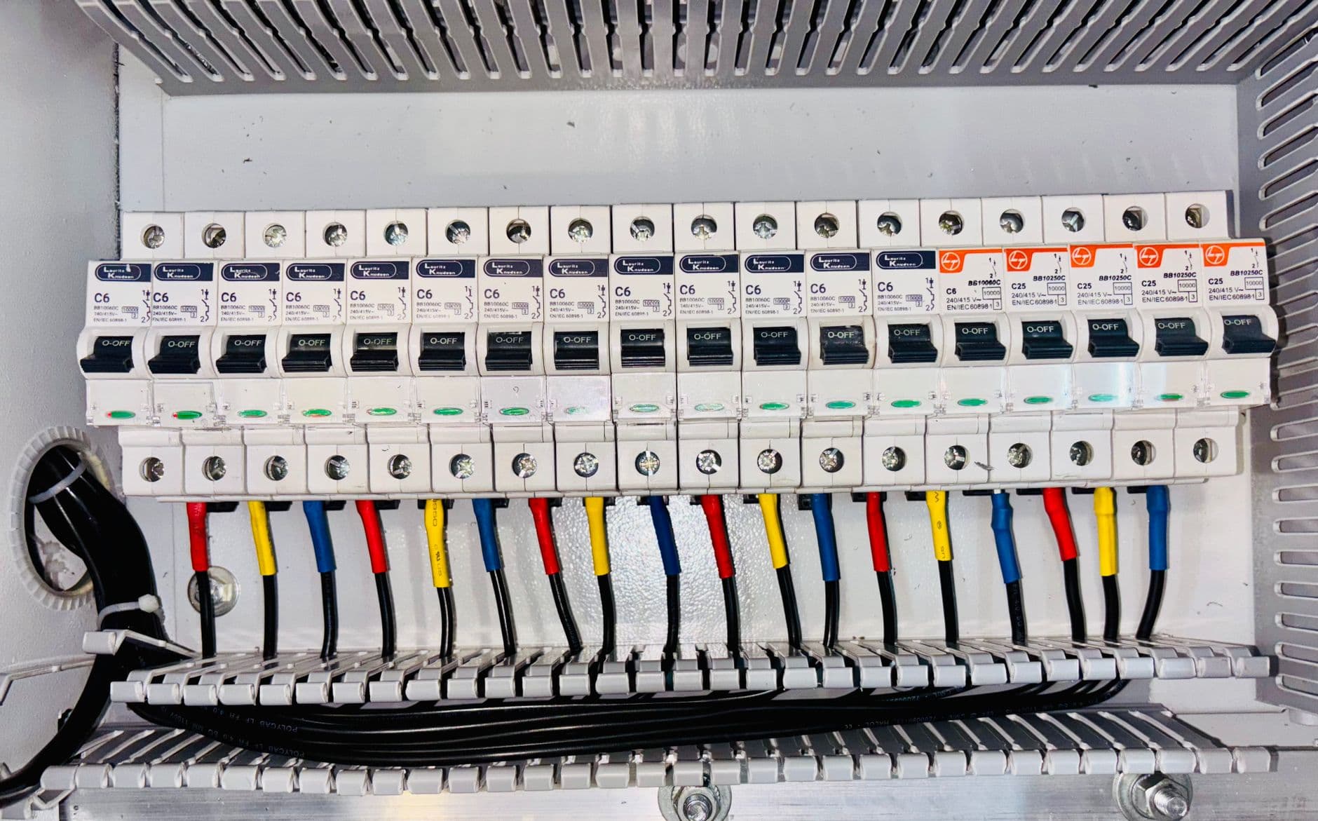 A close-up of an organised, colour-coded circuit breaker panel