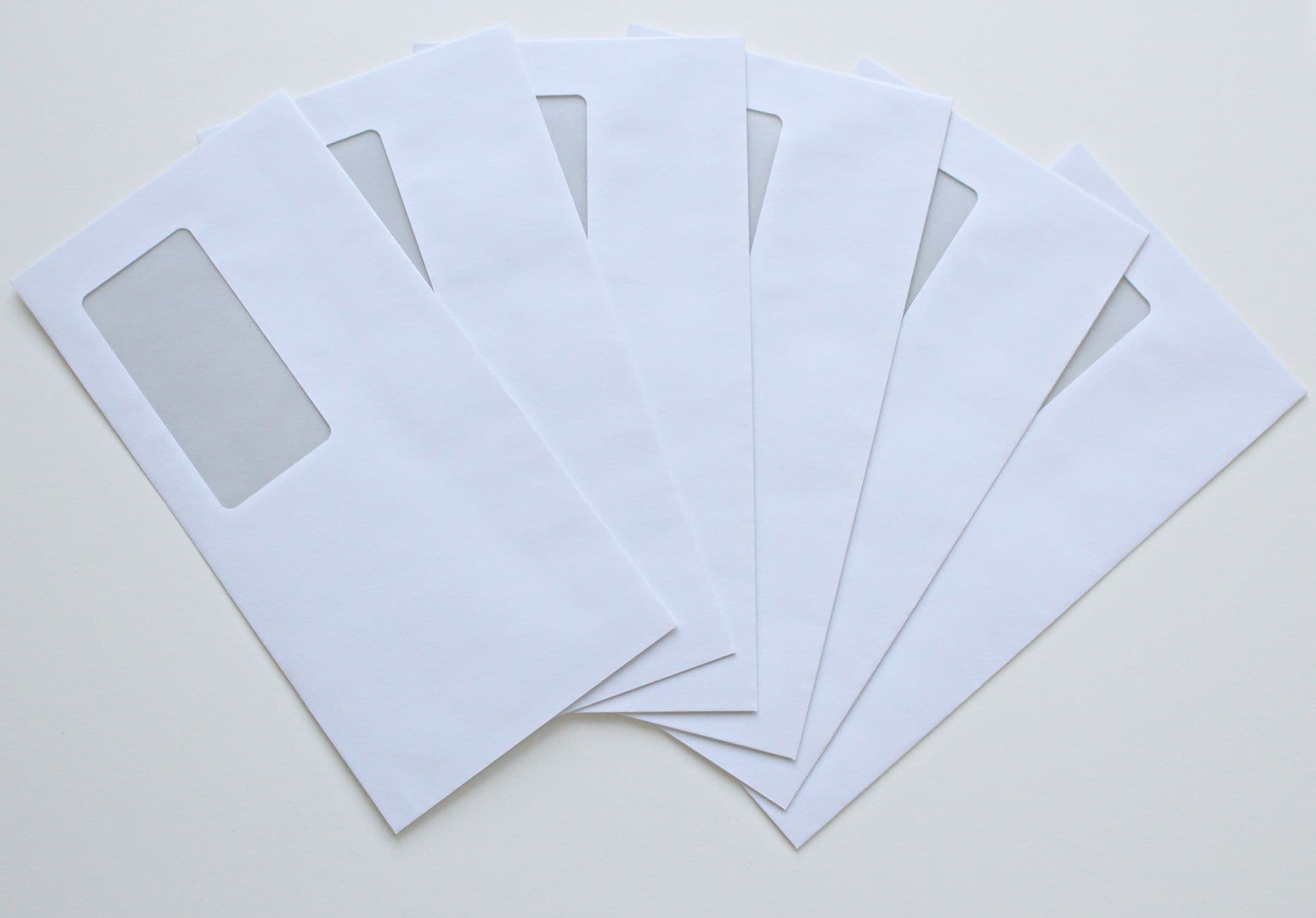 A row of white envelopes fanned out on a flat surface