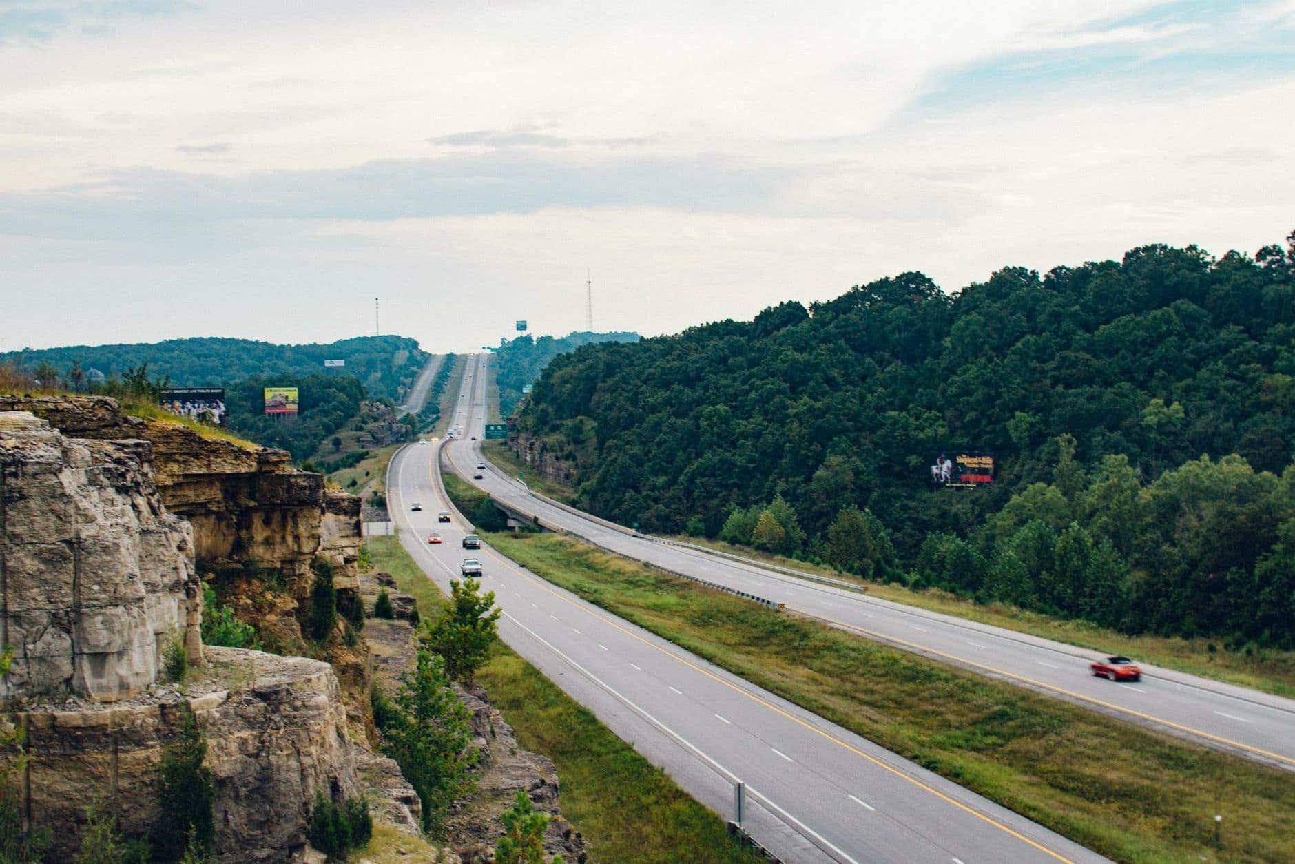 An aerial view of a highway cutting through green countryside