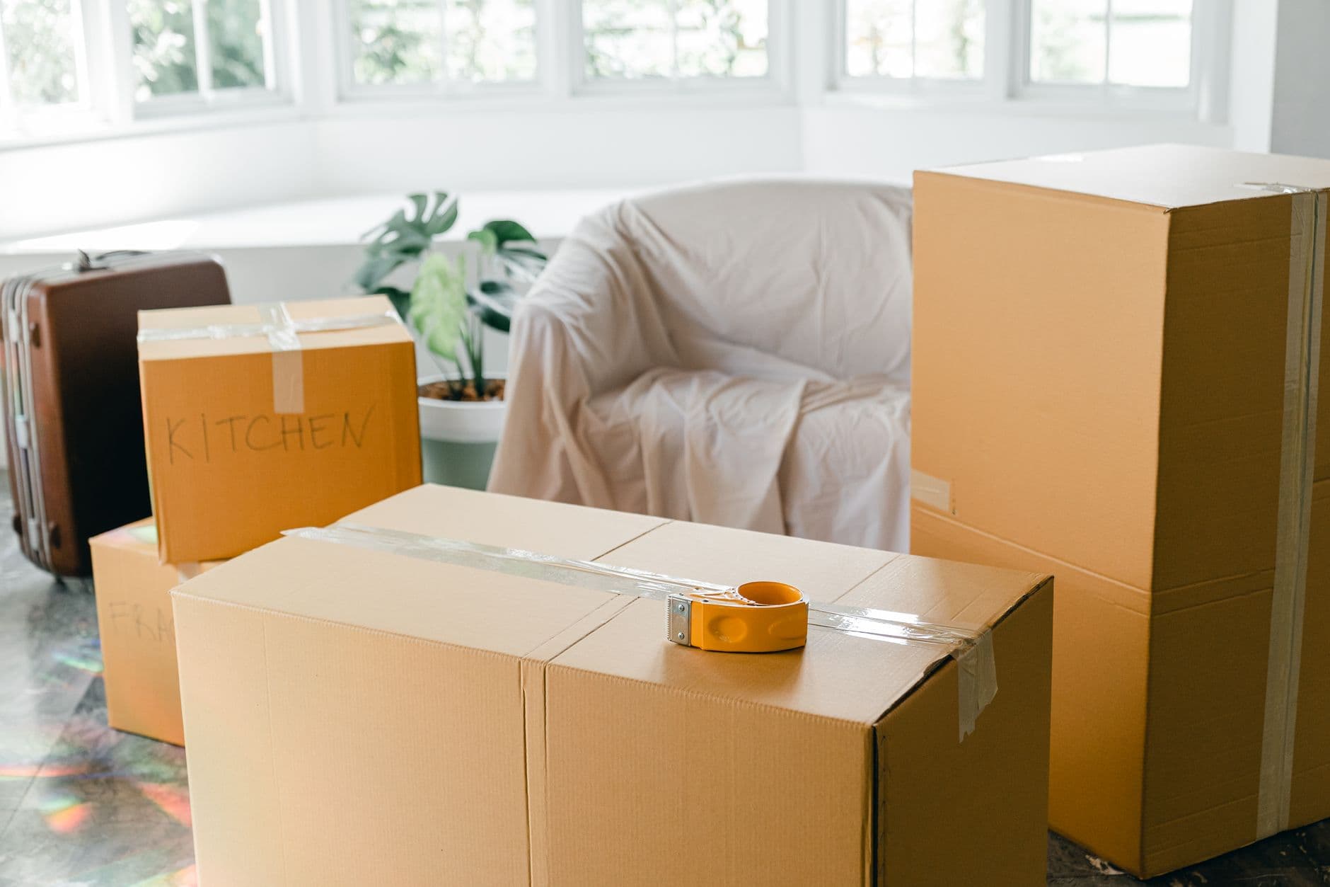 Cardboard boxes and a suitcase packed with household belongings